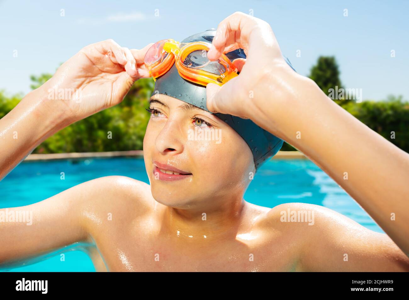 A young boy swimming in an outdoor pool hires stock photography and