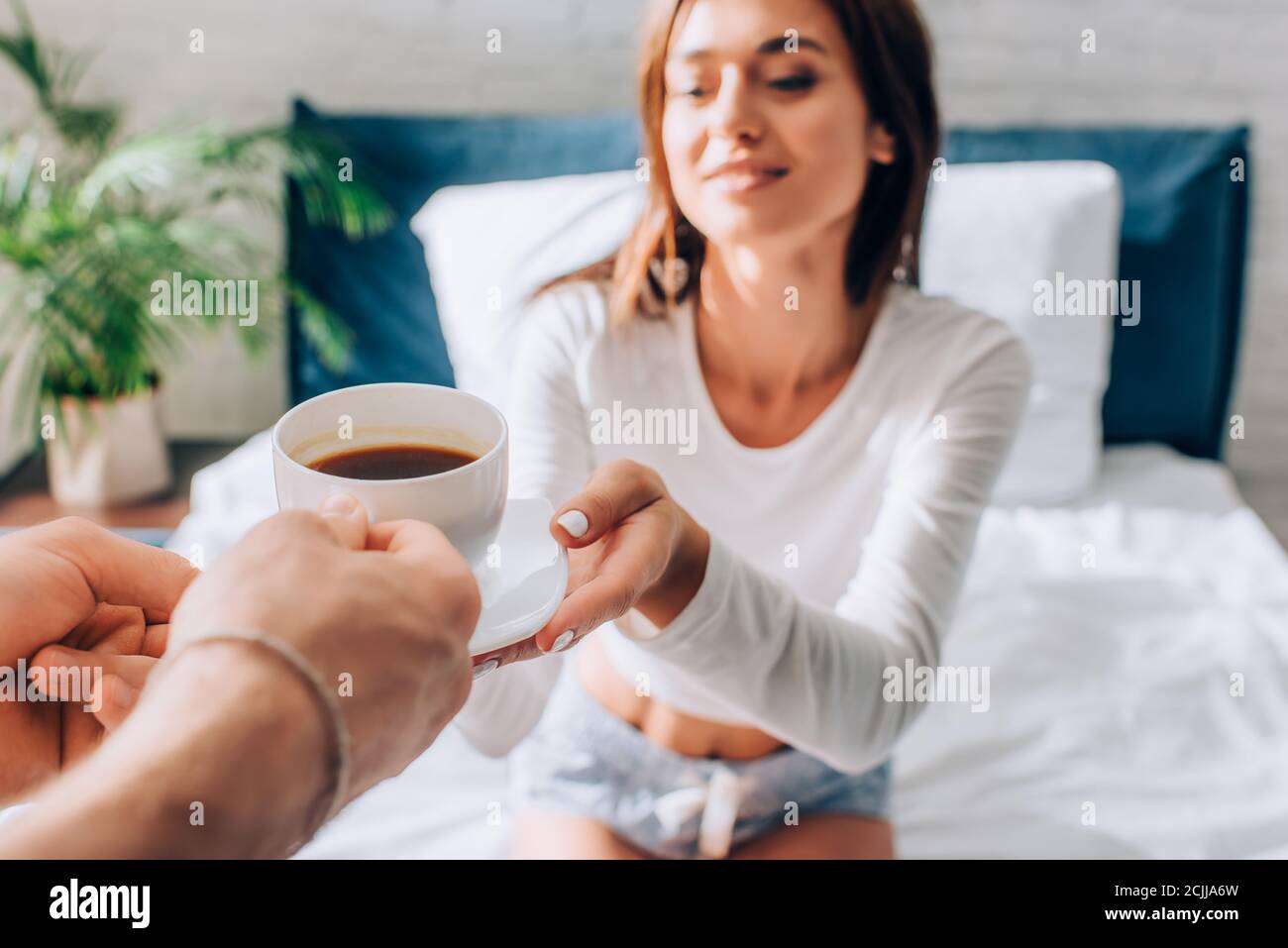 Selective focus of man giving cup of coffee to girlfriend Stock Photo