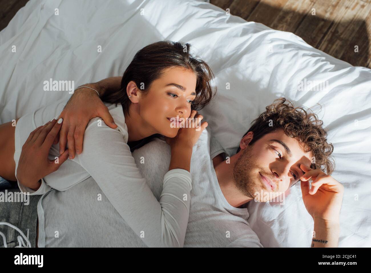 High angle view of couple in pajamas lying on bed at morning Stock ...