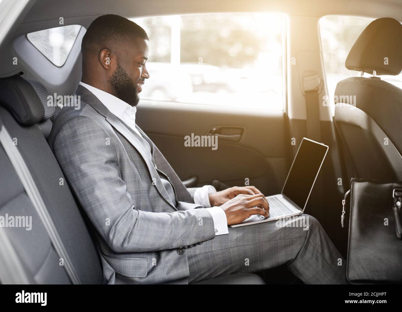 Black guy businessman working on laptop with blank screen Stock Photo