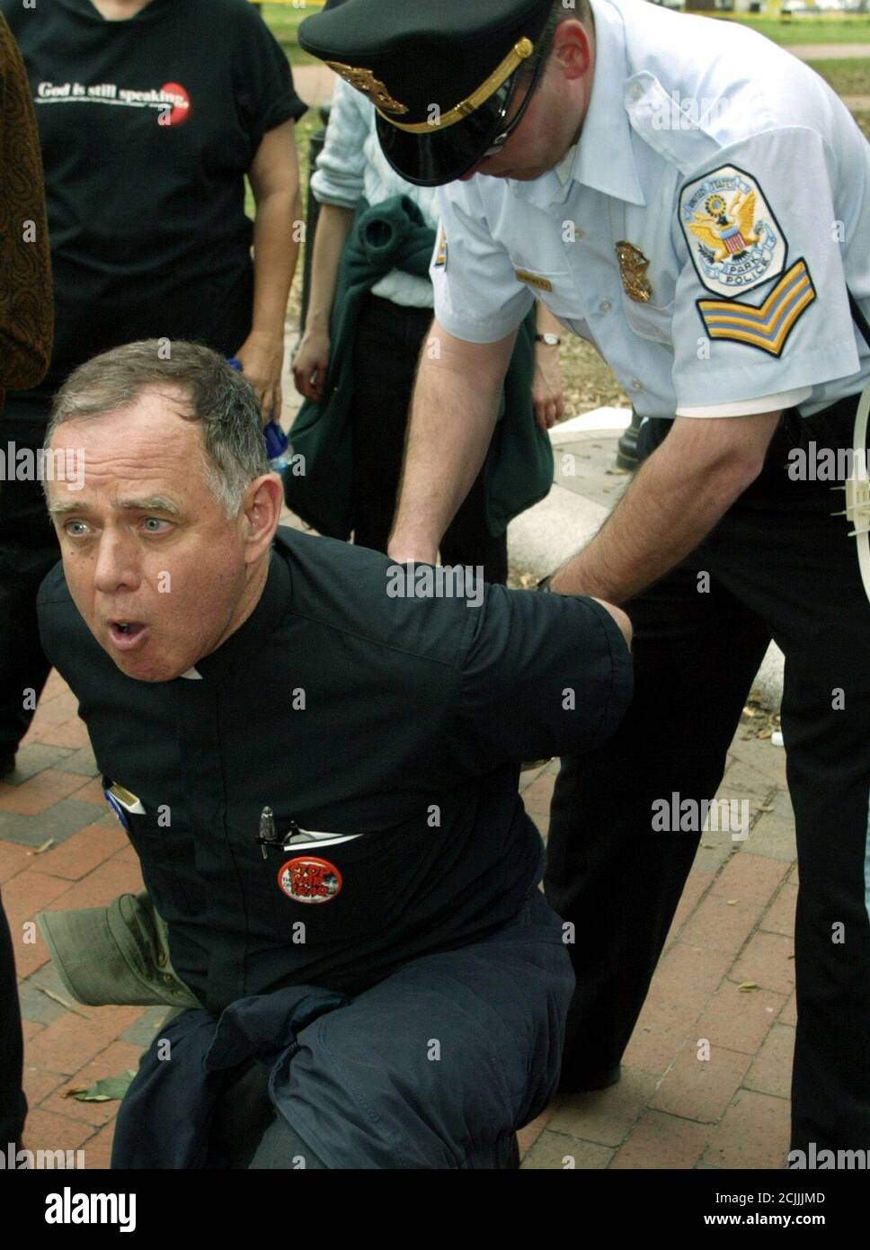 Presbyterian Minister George Taylor, of Hyattsville, Maryland, calls out in protest against the war in Iraq as a U.S. Park police officer arrests him for refusing to leave Lafayette Park, in front of the White House in Washington, March 26, 2003. Religious leaders and members of several peace groups came together for the non-violent civil disobedience action to protest the war in Iraq. REUTERS/Jim Bourg  JRB/SV Stock Photo