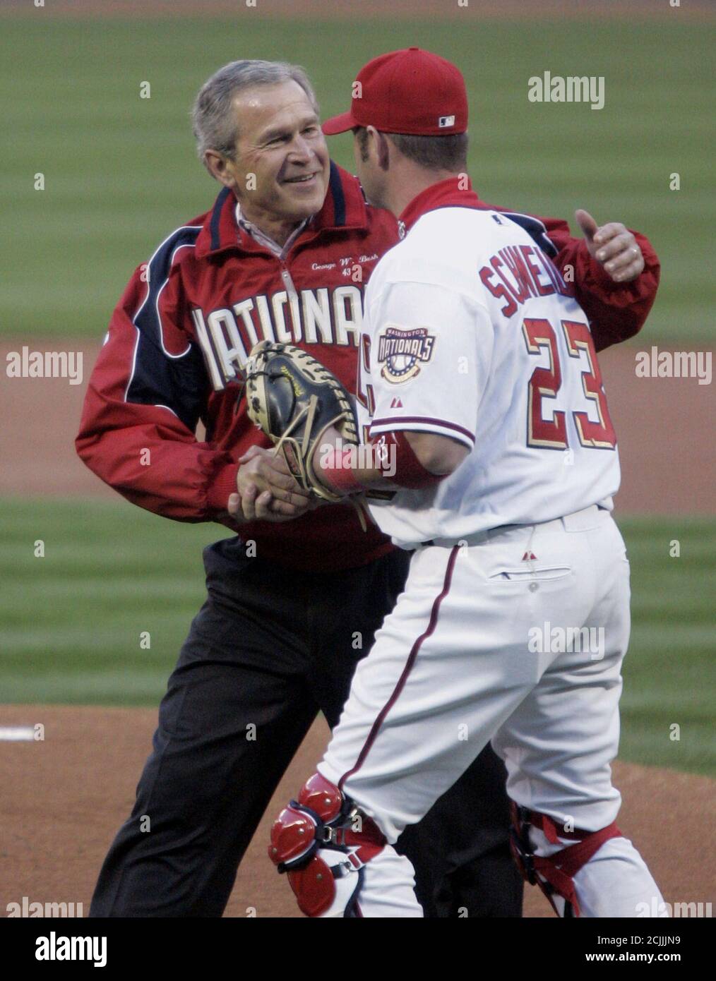 U.S. President George Bush is congratulated by Washington Nationals catcher Brian Schneider (R) after the president threw out the ceremonial first pitch at the Washington Nationals home opener at RFK Stadium in Washington, April 14, 2005. The Nationals are playing the Arizona Diamondbacks in the first regular season baseball game to be played in Washington in 34 years. REUTERS/Jim Bourg  JRB/SV Stock Photo