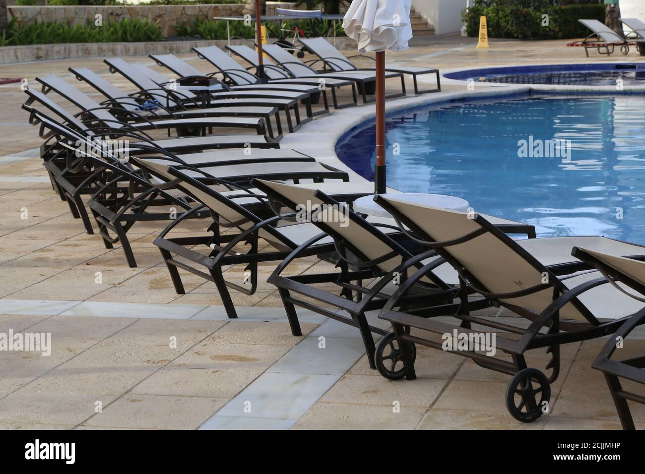 Pool surrounded by folding chairs Stock Photo