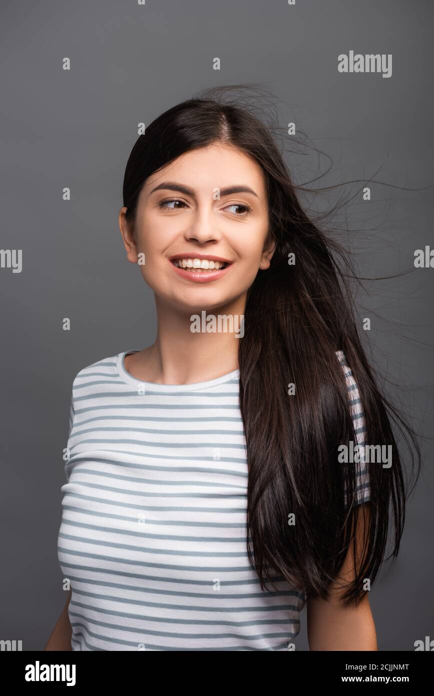 wind blowing through hair of brunette woman isolated on black Stock ...