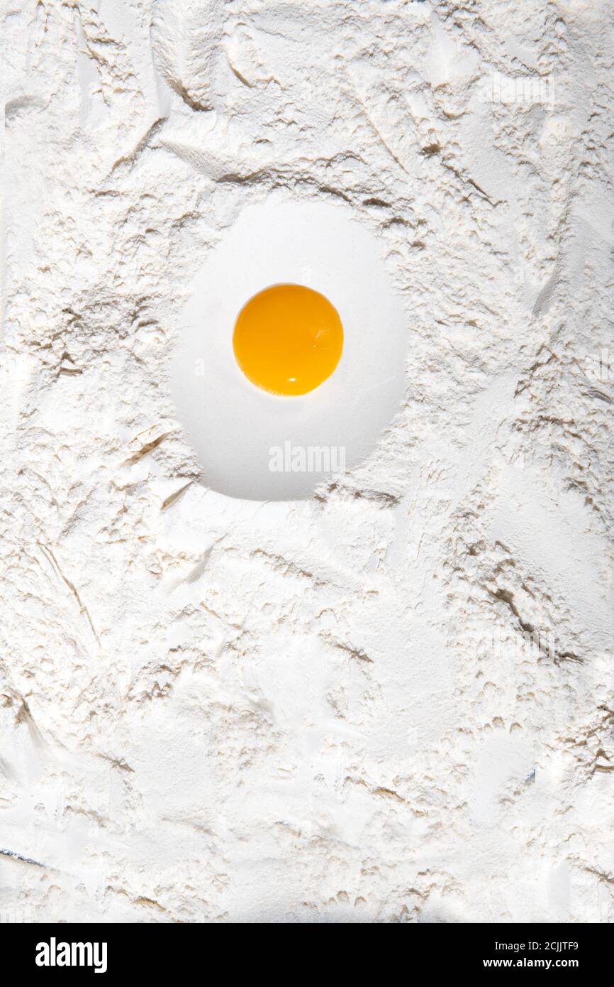 Egg yoke on flour ready to be mixed Stock Photo