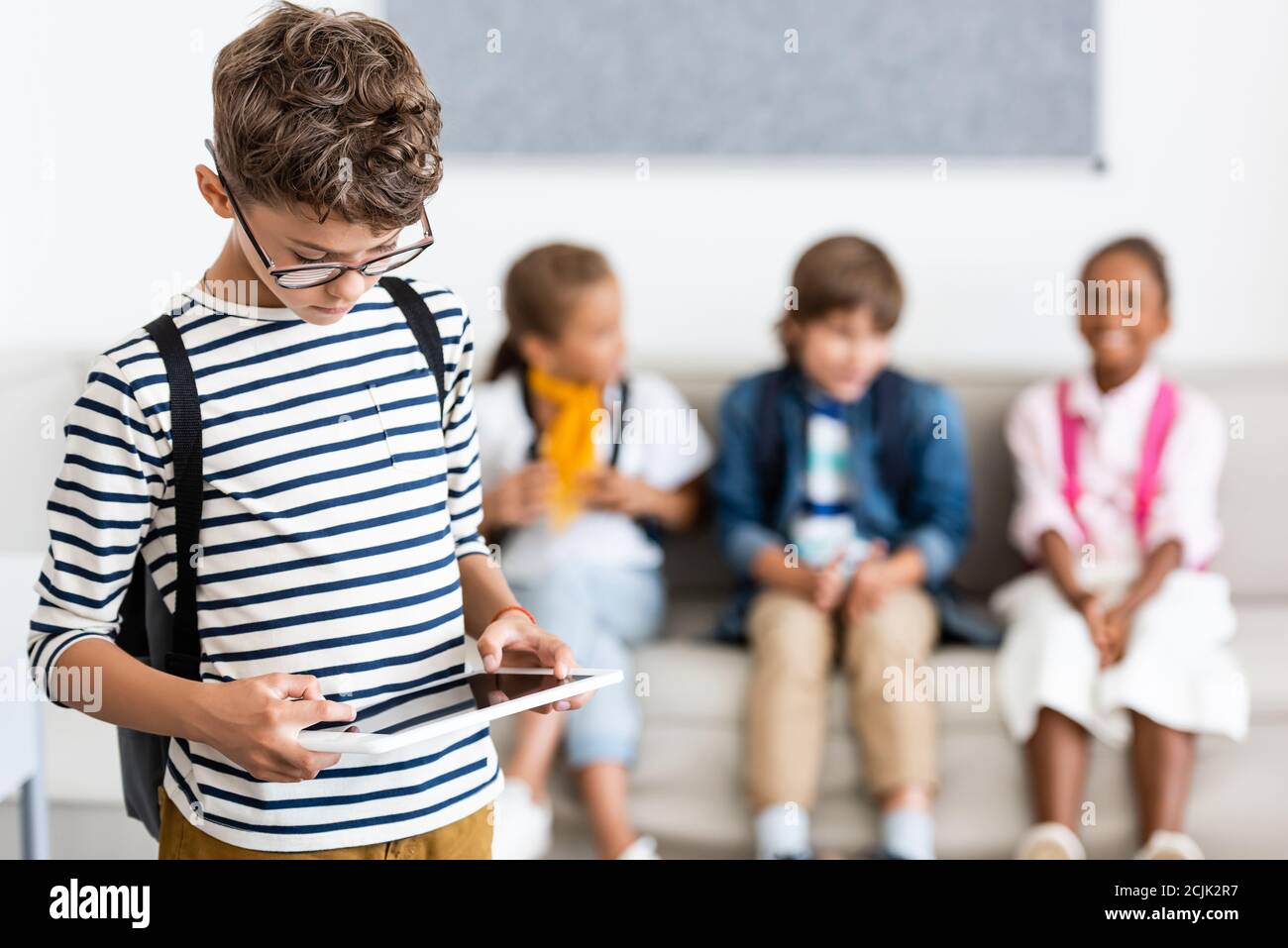 Selective focus of schoolboy using digital tablet in classroom Stock Photo