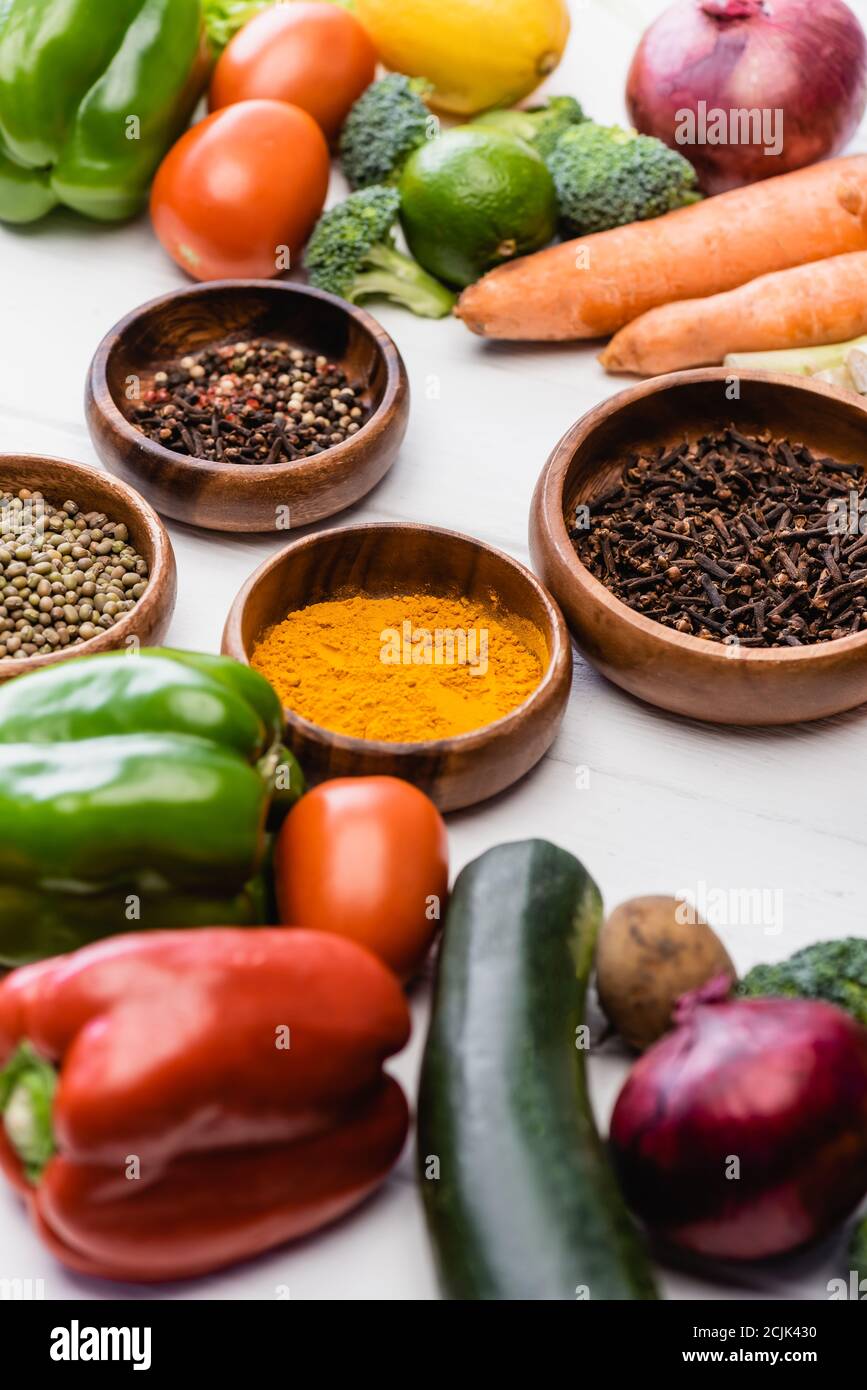 selective focus of fresh ripe vegetables and fruits around bowls with ...