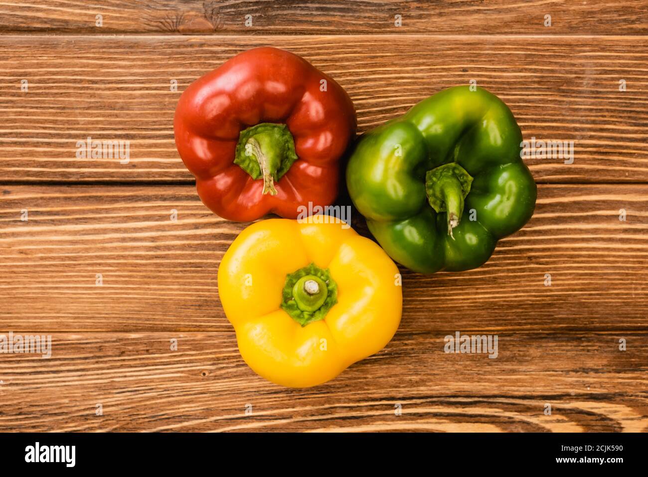 top view of colorful ripe bell peppers on wooden table Stock Photo - Alamy