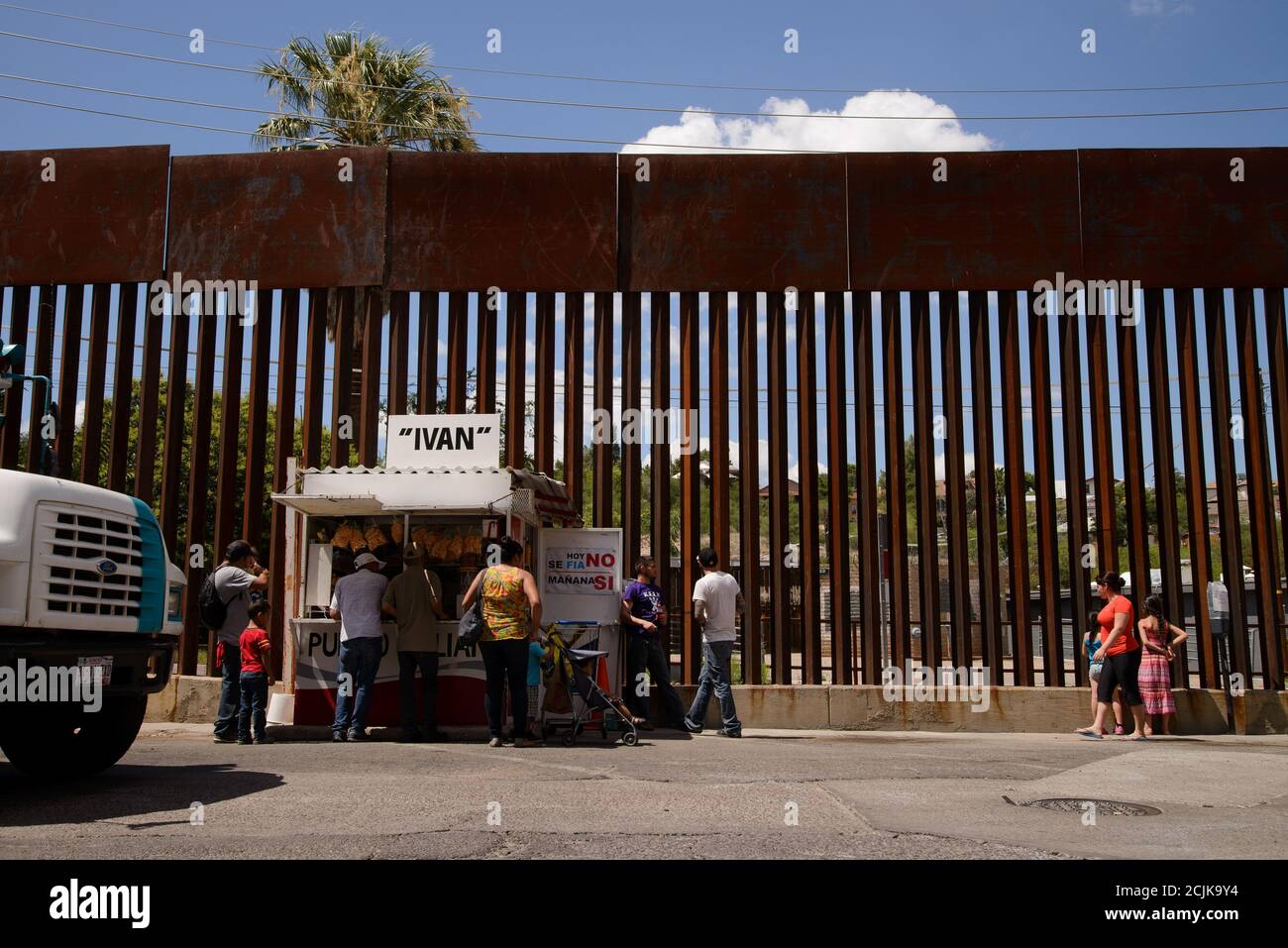 A food vendor operates along the border wall with Nogales, Arizona, USA, in Nogales, Sonora, Mexico. Stock Photo