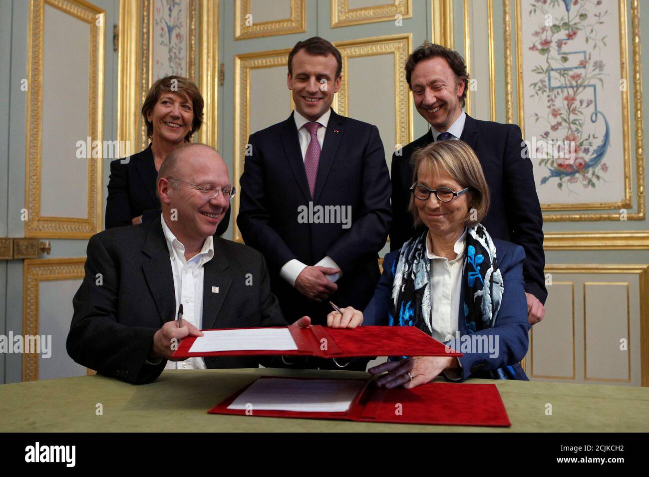 French Culture Minister Francoise Nyssen (R) exchanges a signature agreement with President of the Heritage Foundation Guillaume Poitrinal (L) as French President Emmanuel Macron (C) flanked with Stephan Pallez, President of the French Lottery 'Francaise des Jeux' (L) and French TV host Stephane Bern (R) look on during a cultural heritage agreement meeting at the Elysee Palace in Paris, France, February 13, 2018. REUTERS/Francois Mori/Pool Stock Photo