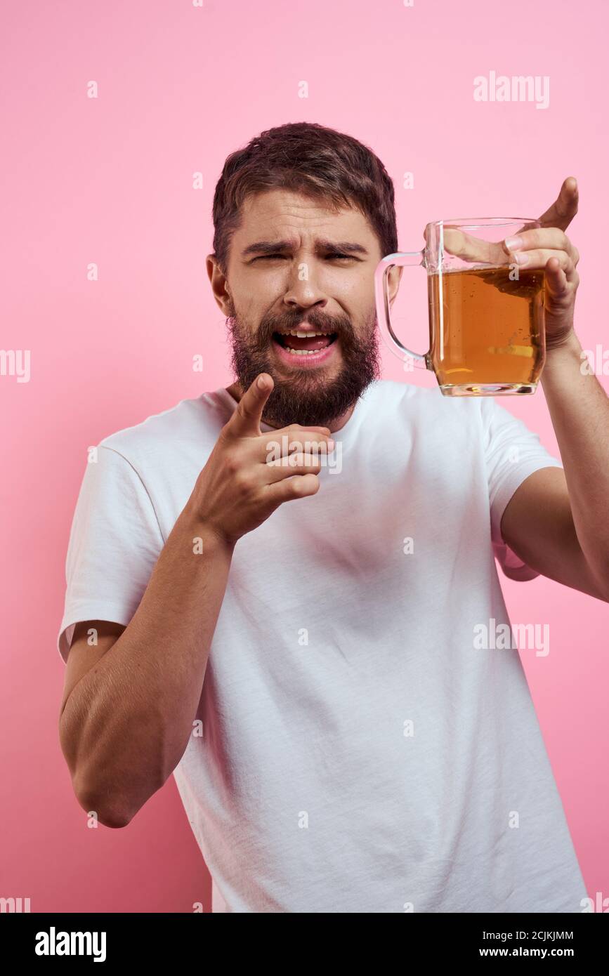 Bearded man with a mug of beer On a pink background fun emotions