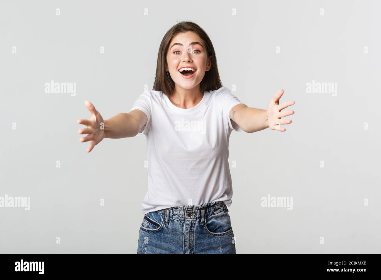 Excited beautiful girl extend hands forward, reaching for hug and ...
