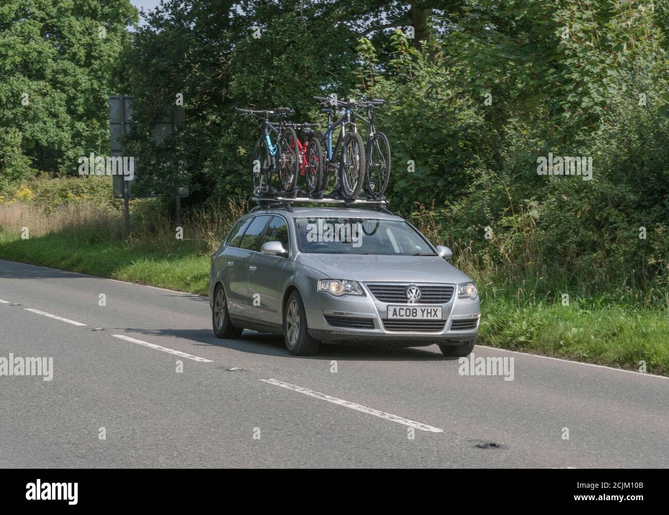 VW Volkswagen estate car with cycle car rack and bicycles mounted on the roof in Cornwall. For UK staycation, cycling holiday, cycling enthusiasts. Stock Photo