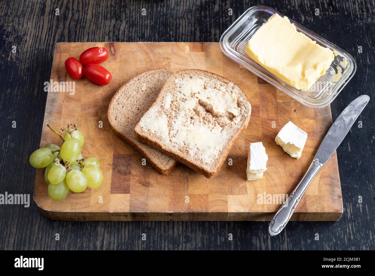 Lunchtime Sandwich Making Two Slices Of Bread Butter Cheese Tomatoes And Grapes On A Wooden Cutting Board Stock Photo Alamy Lunchtime Sandwich Making Two Slices Of Bread Butter Cheese Tomatoes And Grapes On A Wooden Cutting Board Stock Photo Alamy