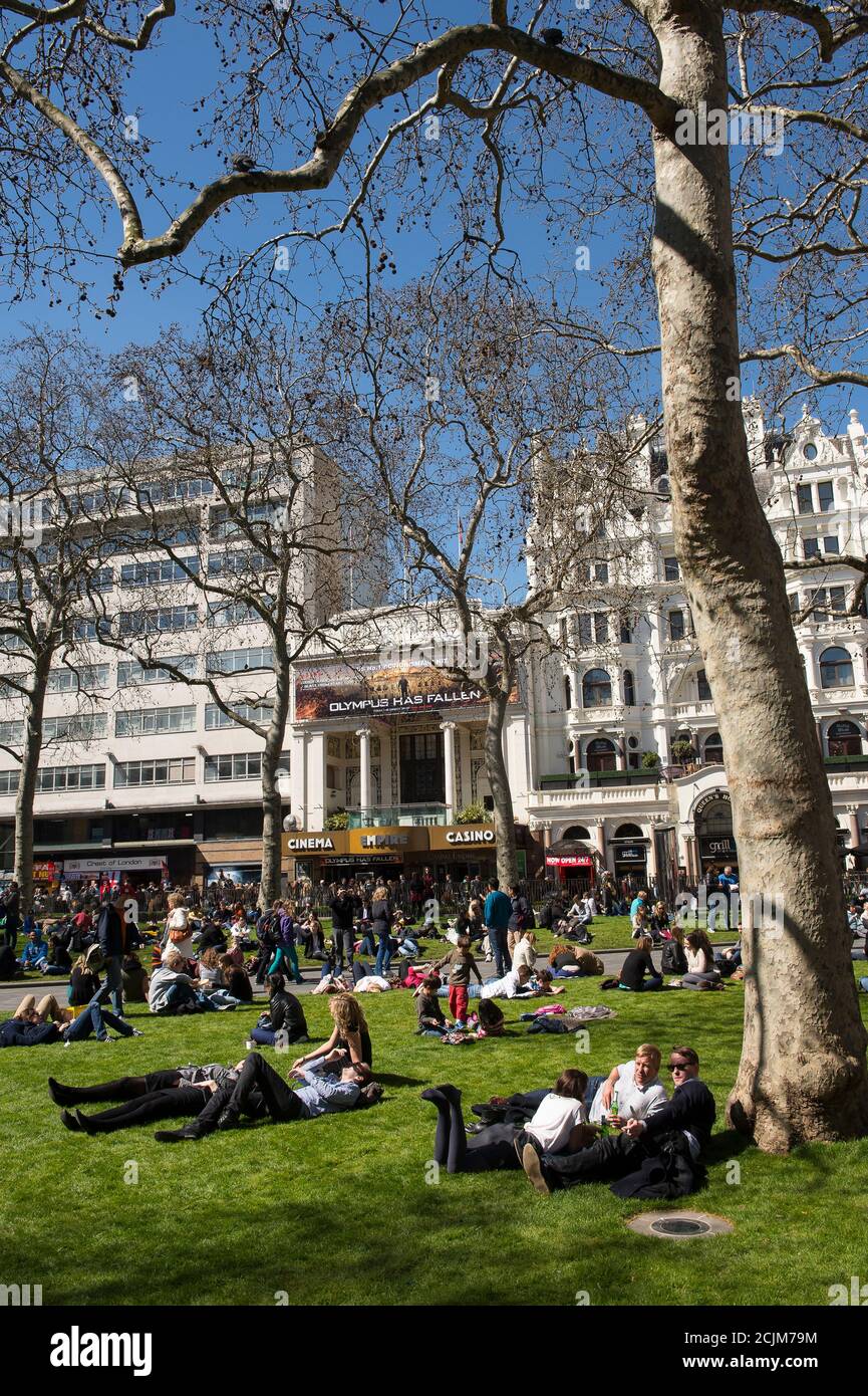 People relaxing in Leicester Square in the West End of London, England. Stock Photo