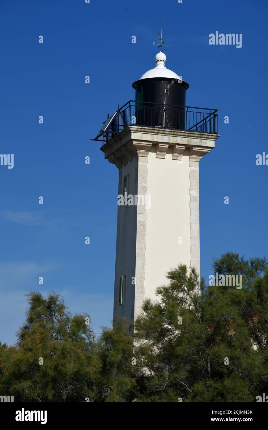 Gacholle Lighthouse on the Digue à la Mer or Coastal Dyke in the Camargue Nature Reserve & Halophyte Vegetation Les Saintes-Maries-de-la-Mer Provence Stock Photo