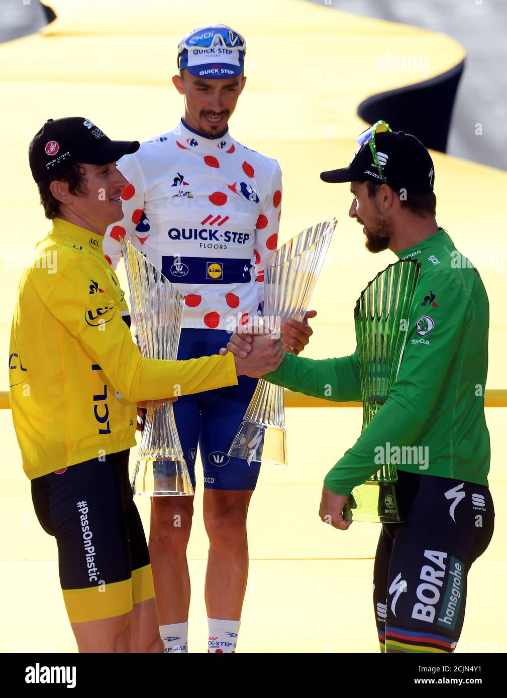 Cycling - Tour de France - The 116-km Stage 21 from Houilles to Paris Champs-Elysees - July 29, 2018 - BORA-Hansgrohe rider Peter Sagan of Slovakia, wearing the green jersey as winner of the points classification, congratulates overall winner Team Sky rider Geraint Thomas of Britain on the podium, as Quick-Step Floors rider Julian Alaphilippe of France, wearing the polka-dot jersey as winner of the mountains classification, looks on. Stephane Mantey/Pool via REUTERS Stock Photo