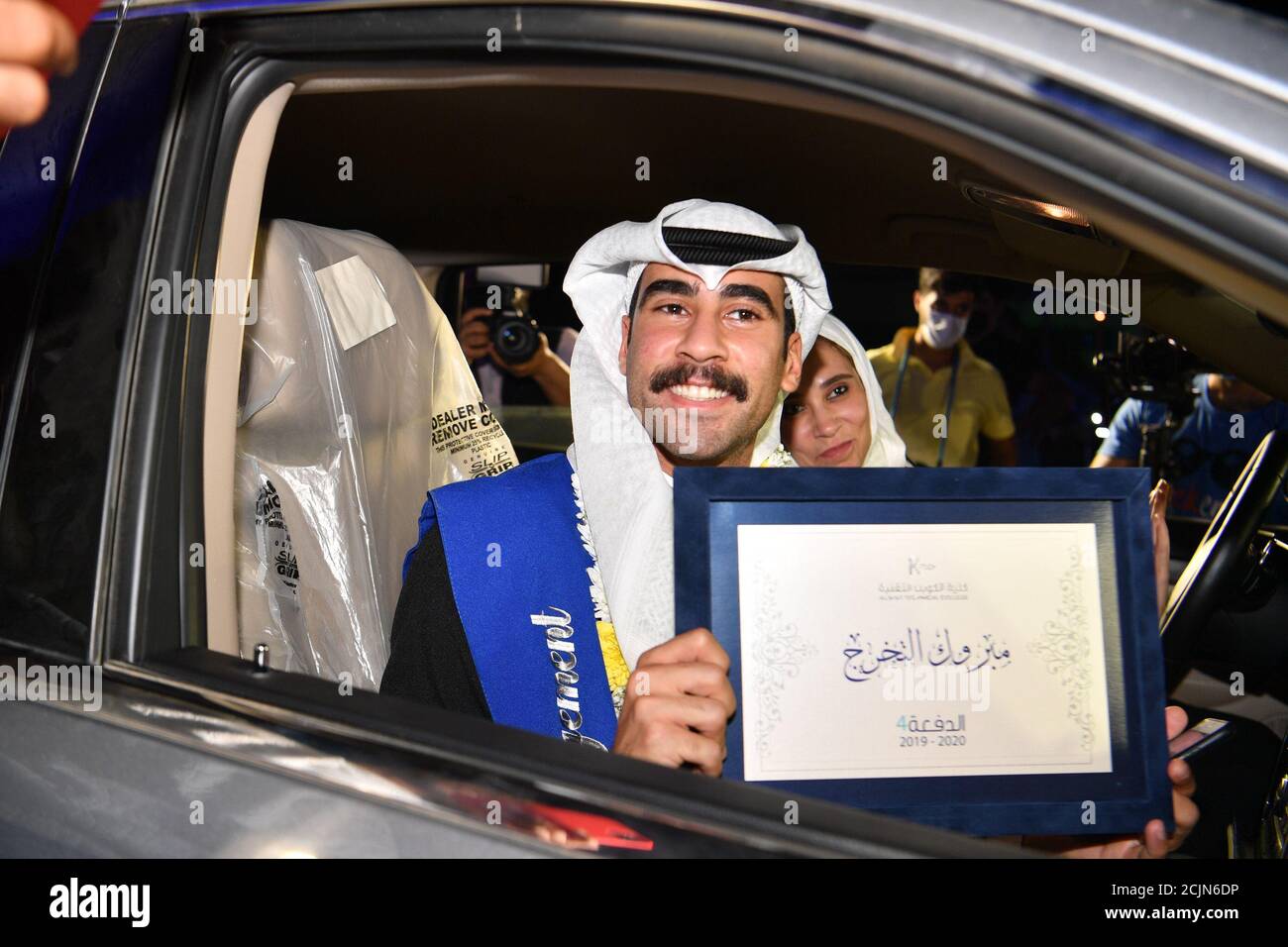 (200915) -- AHMADI GOVERNORATE, Sept. 15, 2020 (Xinhua) -- A student shows a diploma during a drive-through graduation ceremony at Kuwait Technical College (K-Tech) in Ahmadi Governorate, Kuwait, Sept. 9, 2020. Kuwait Technical College (K-Tech) celebrated its students' graduation in the first of its kind drive-through ceremony. More than 125 students gathered in the university's parking lot to receive their degree while driving-through to the president and keeping social distancing protocols in place. TO GO WITH 'Feature: Kuwaiti students celebrate graduation with drive-through, virtua Stock Photo