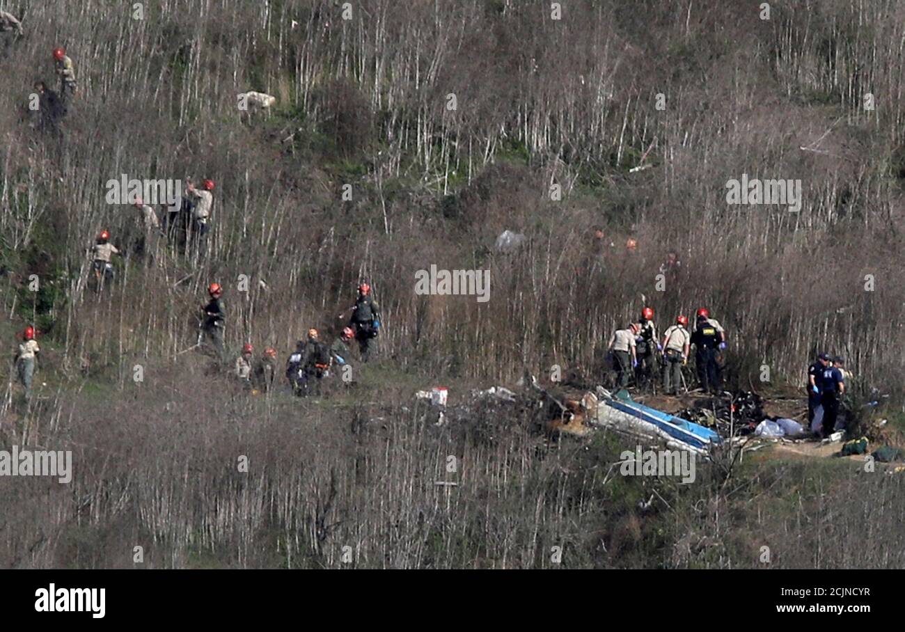 Investigators work at the scene of the helicopter crash which killed