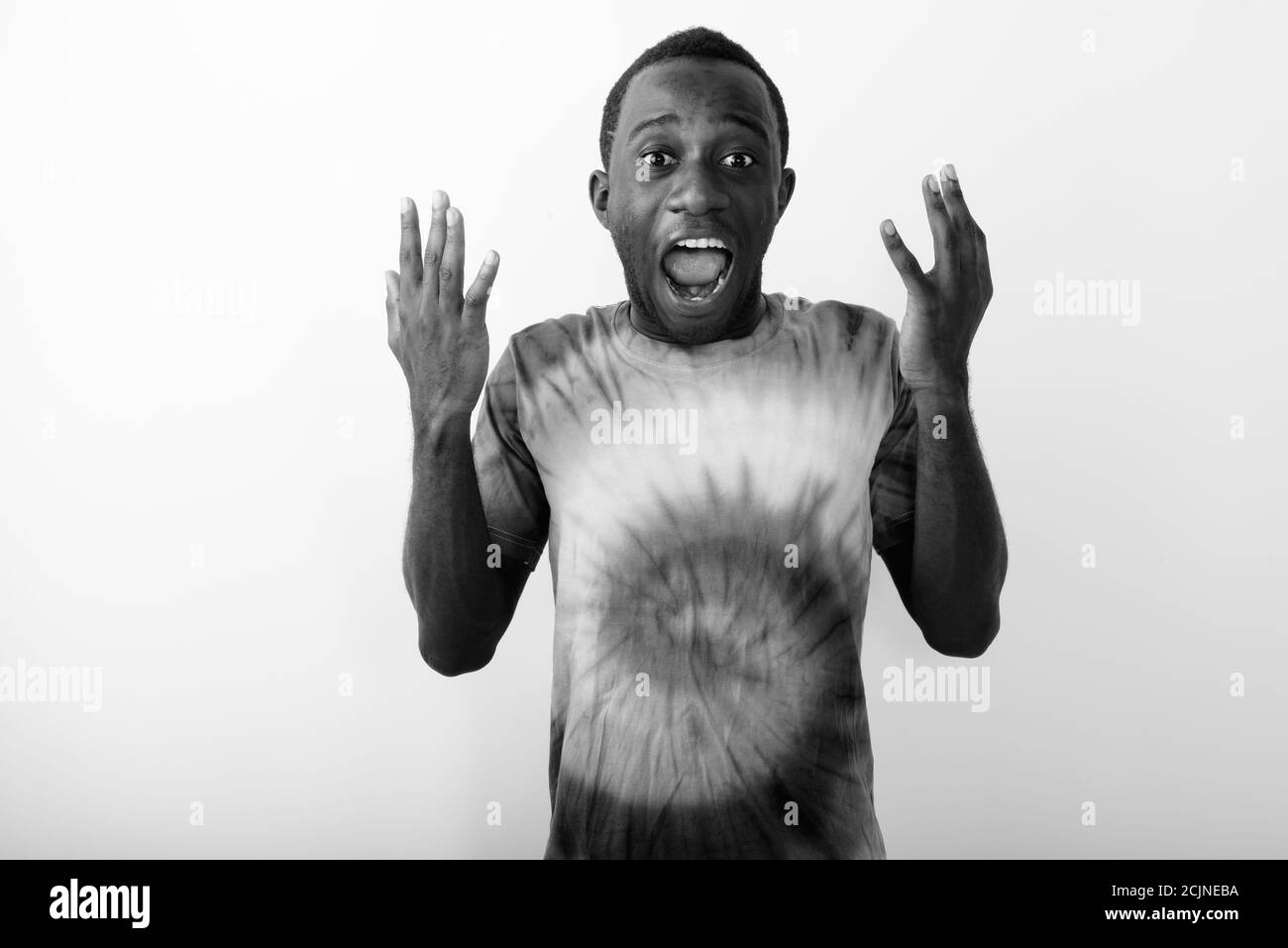 Studio shot of young surprised black African man looking shocked against white background Stock Photo