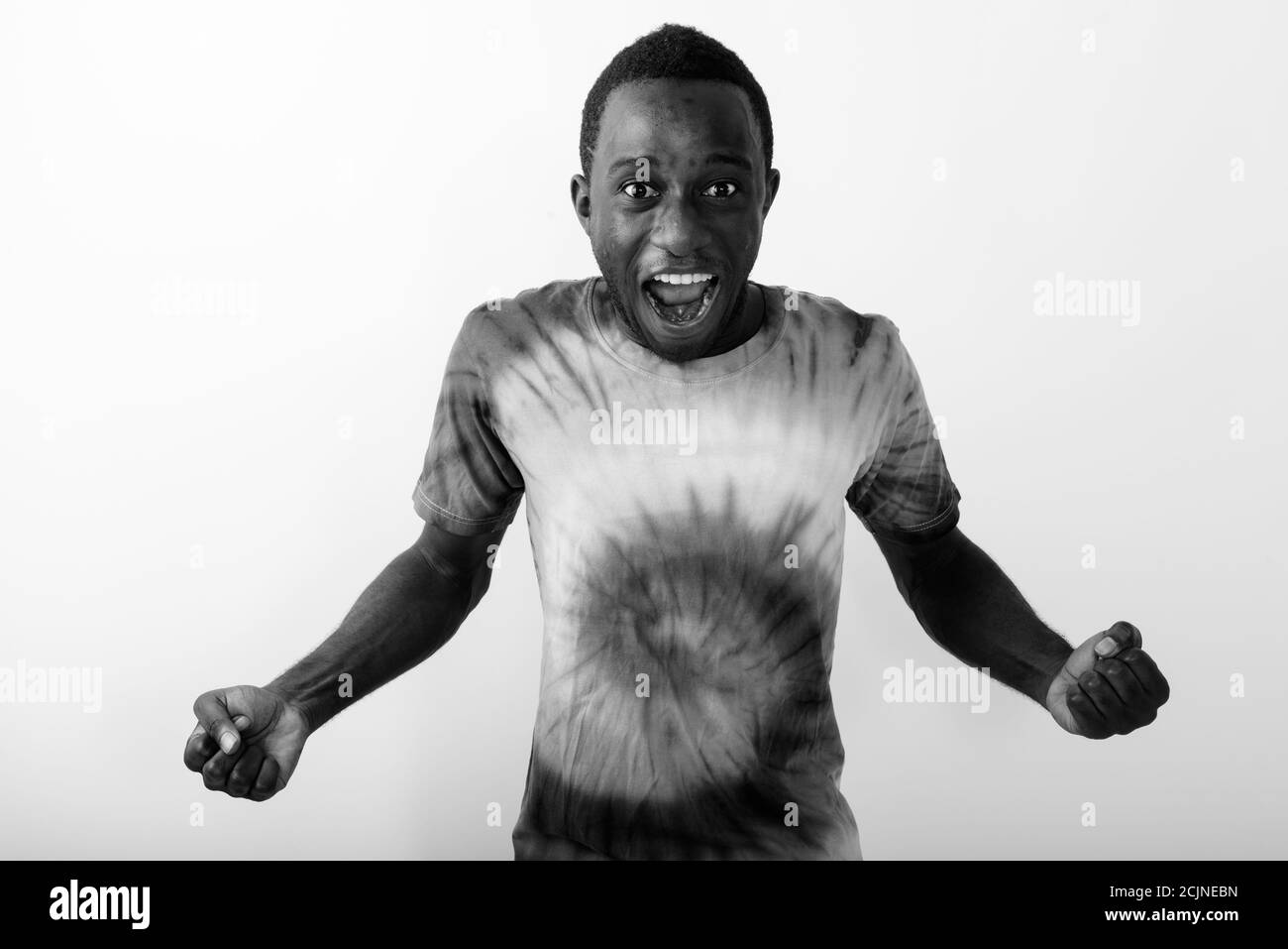 Studio shot of young black African man screaming against white background Stock Photo