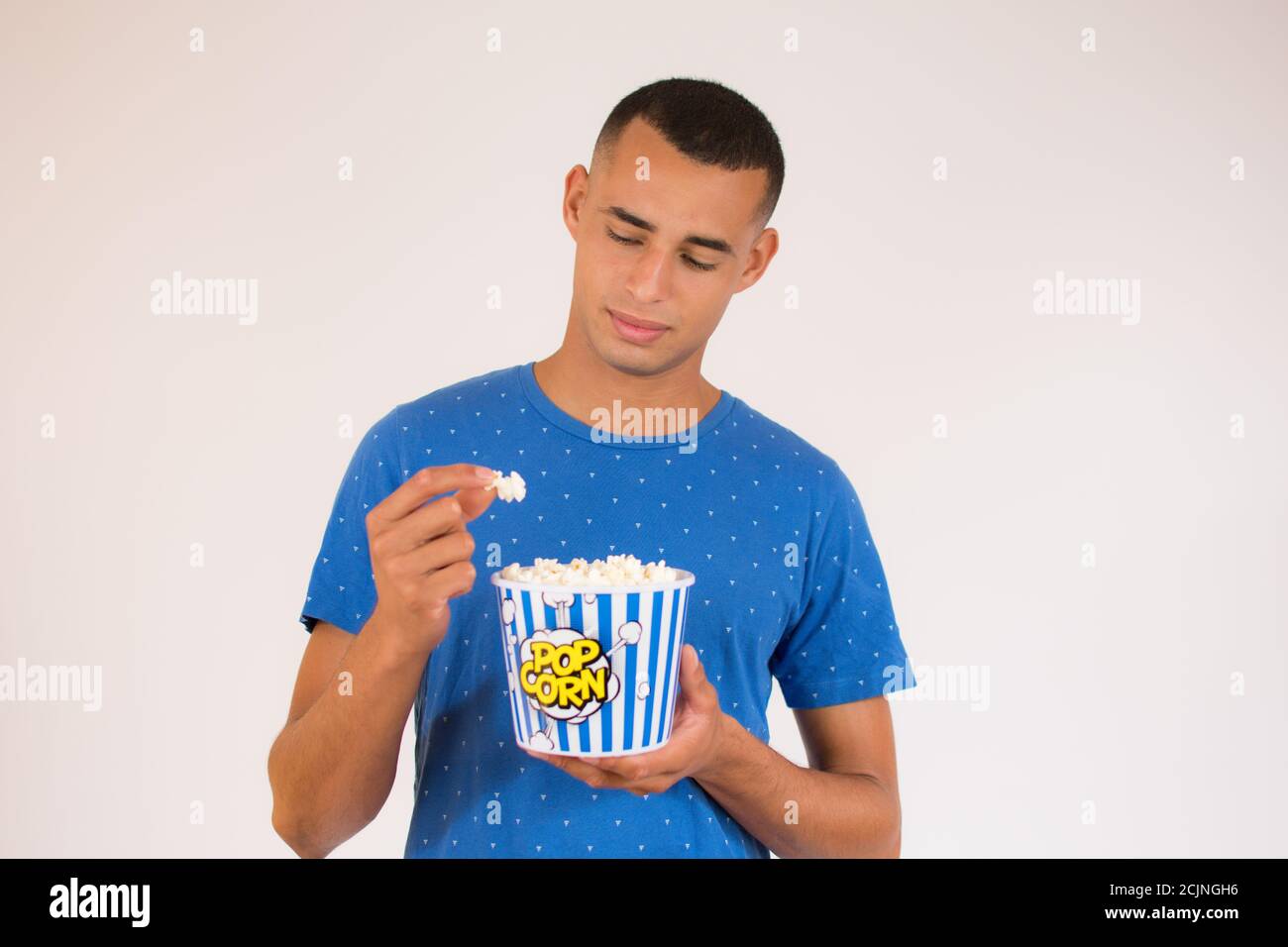 Young man eating popcorn Stock Photo Alamy