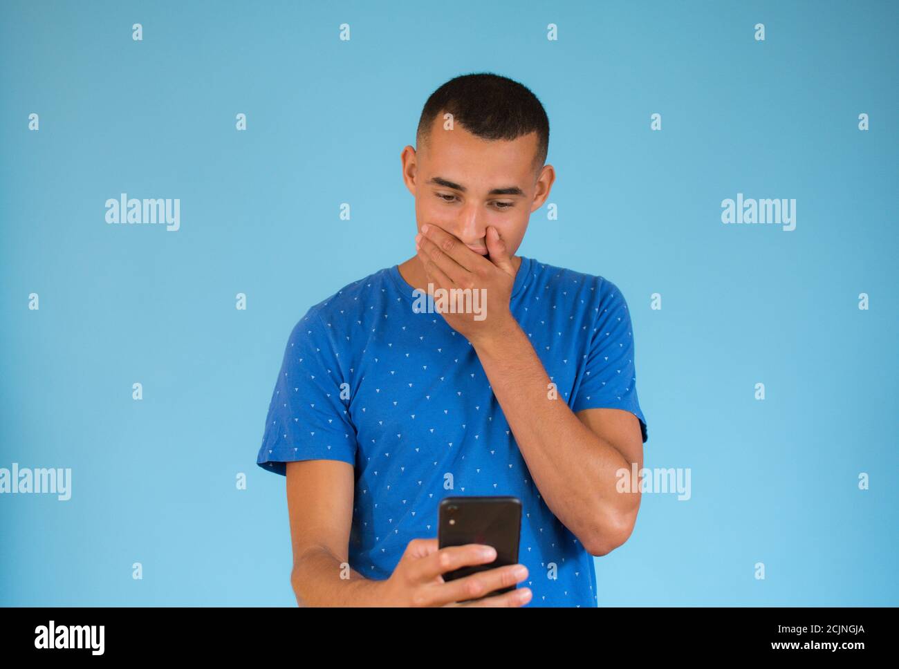 Surprised young man talking to mobile Stock Photo