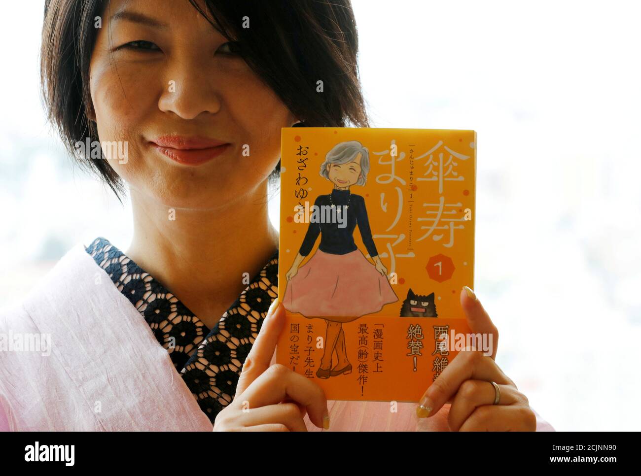 Yuki Ozawa, the comic book author of Sanju Mariko, poses with her comic  book during an