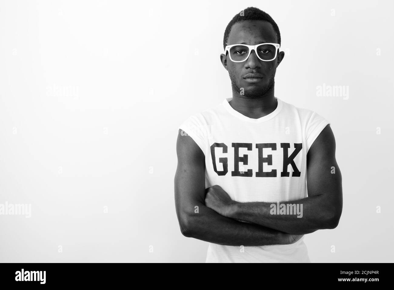 Studio shot of young confident black African nerd man wearing Geek shirt against white background Stock Photo