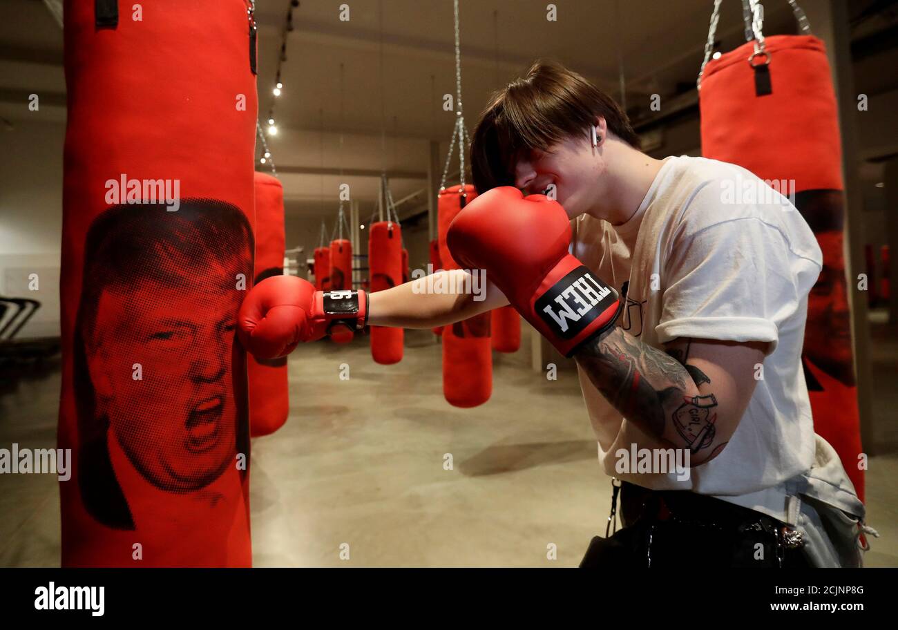 A visitor hits a punching bag with an image depicting U.S. President Donald  Trump, as part of an interactive installation called "Welcome in Hard  Times", that allows visitors to release their anger