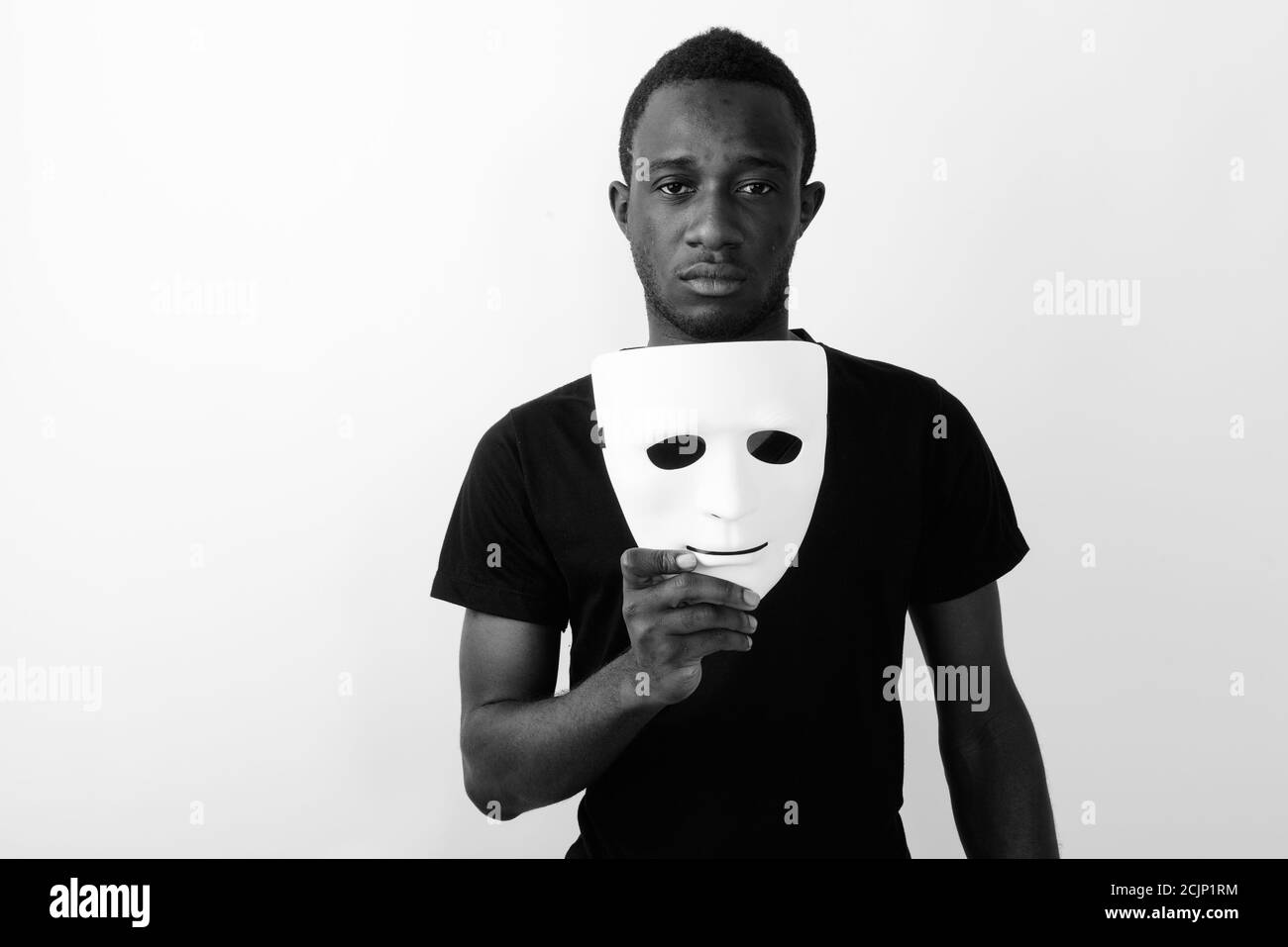 Studio shot of young black African man holding mask Stock Photo