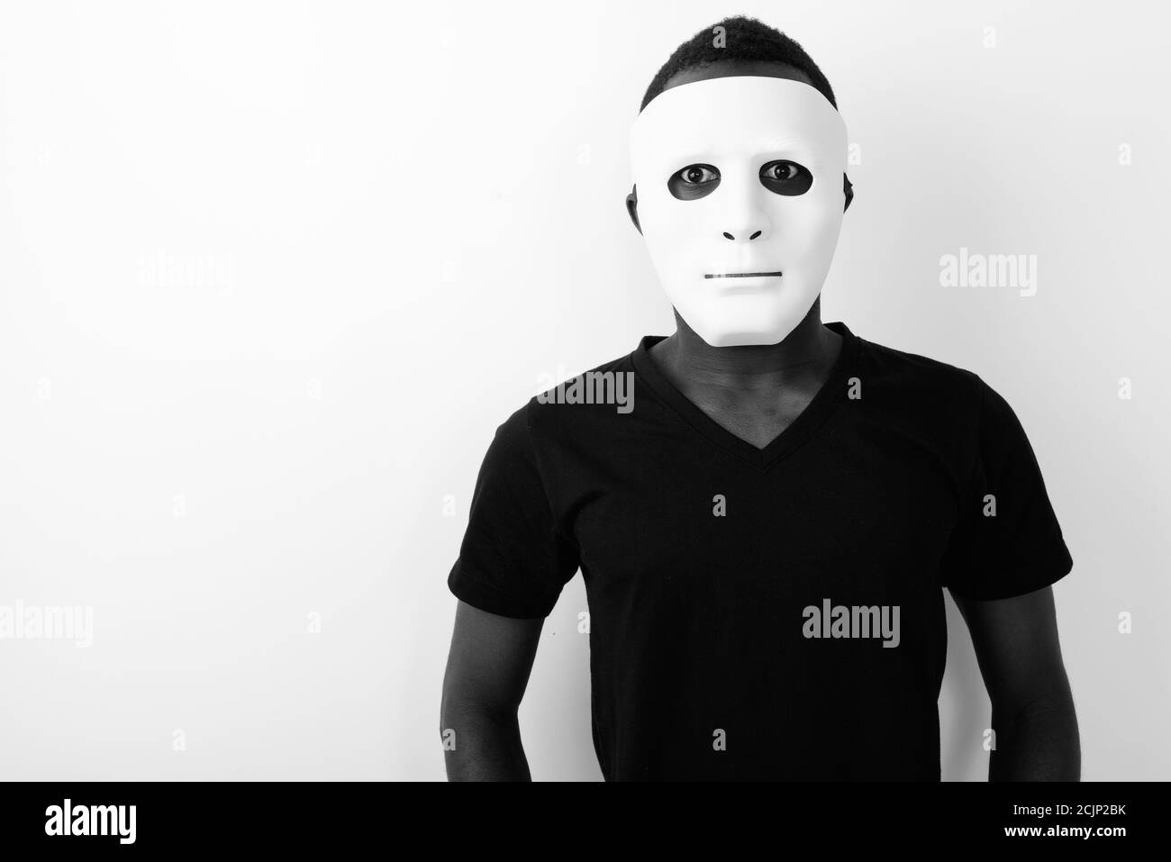 Studio shot of young black African man wearing mask Stock Photo