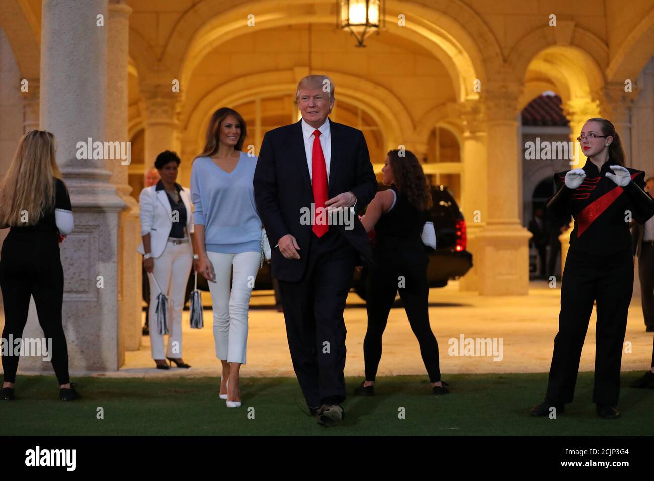 U.S. President Donald Trump and First Lady Melania Trump greet a marching  band as they arrive at Trump International Golf club to watch the Super Bowl  LI between New England Patriots and