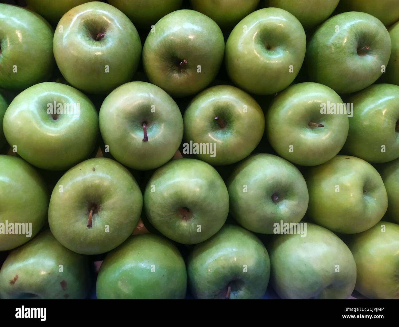 Background of raw green apple fruit groups in perspective, part of a