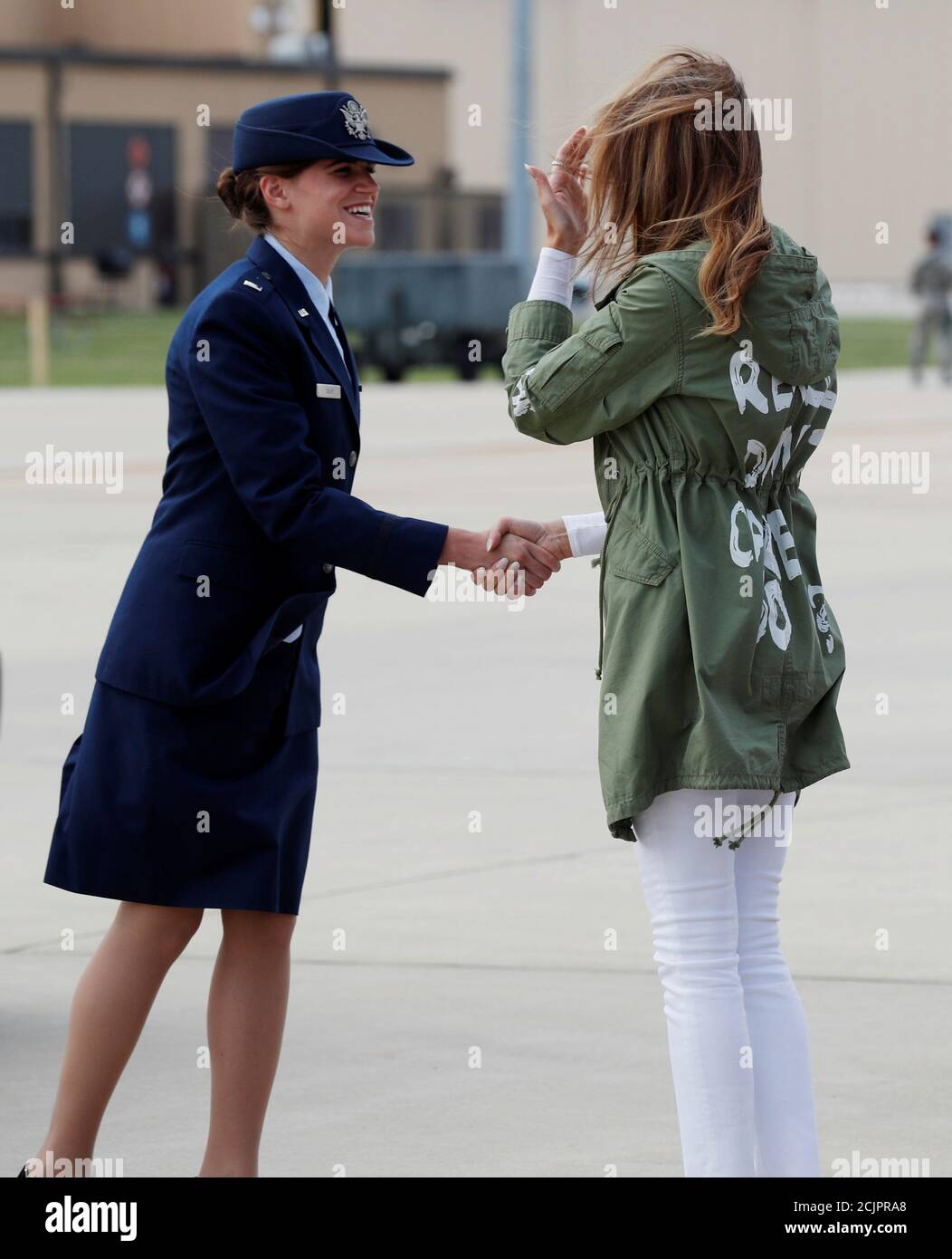 U.S. first lady Melania Trump is greeted on the tarmac by a U.S. Air Force  officer as the first lady returns to Washington wearing a Zara design jacket  with the phrase "I
