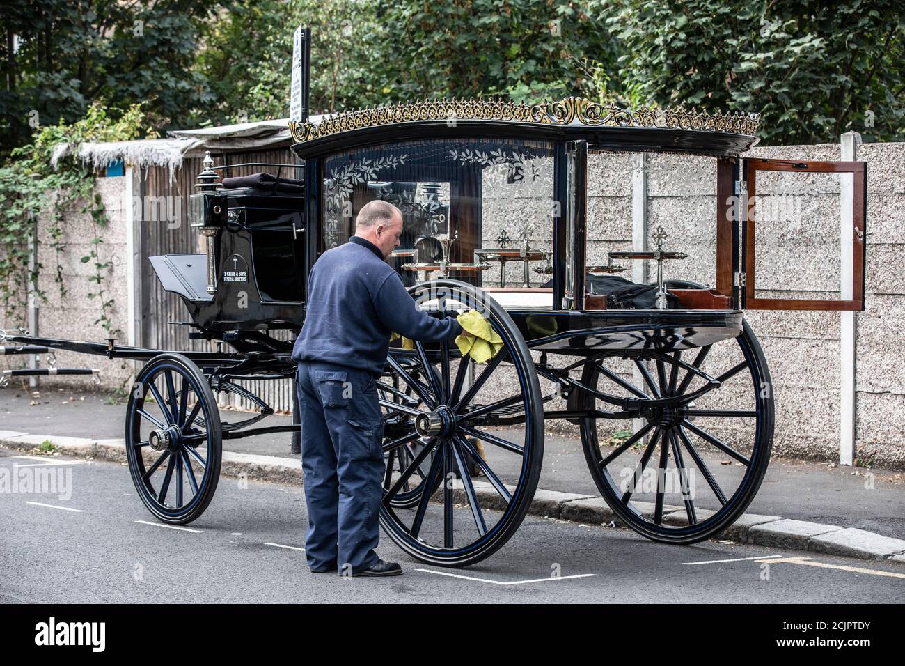 Victorian 1910 Horse Drawn Hearse, used by T Cribb & Sons Funeral Directors, being prepared roadside for a funeral in East London, England, UK Stock Photo
