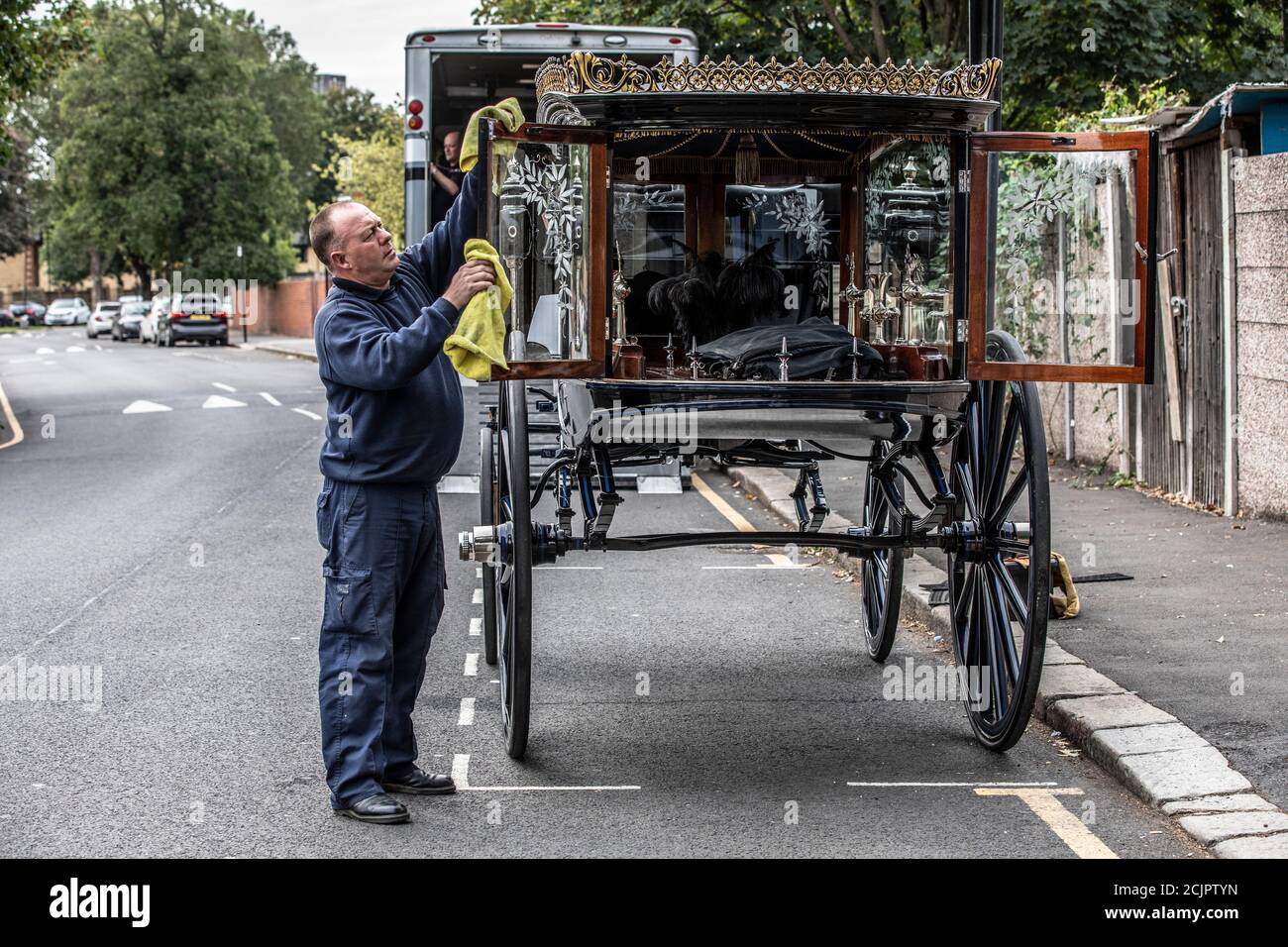 Victorian 1910 Horse Drawn Hearse, used by T Cribb & Sons Funeral Directors, being prepared roadside for a funeral in East London, England, UK Stock Photo