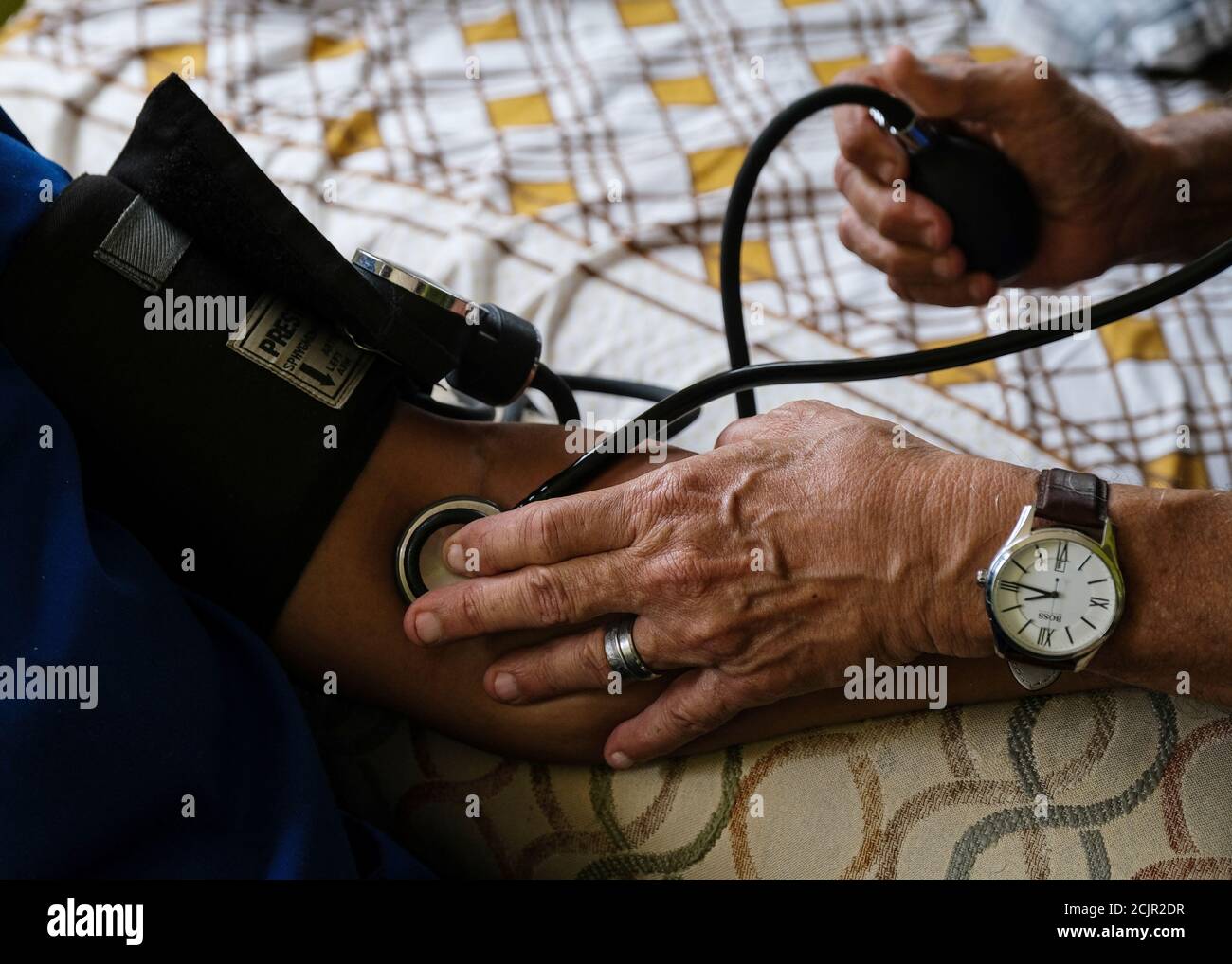Dr. Zoilo López checks the blood pressure of a Bahamian woman in Eight Mile Rock settlement in Grand Bahama, Bahamas, October 5, 2019. Picture taken October 5, 2019.    REUTERS/Gabriella N. Baez Stock Photo
