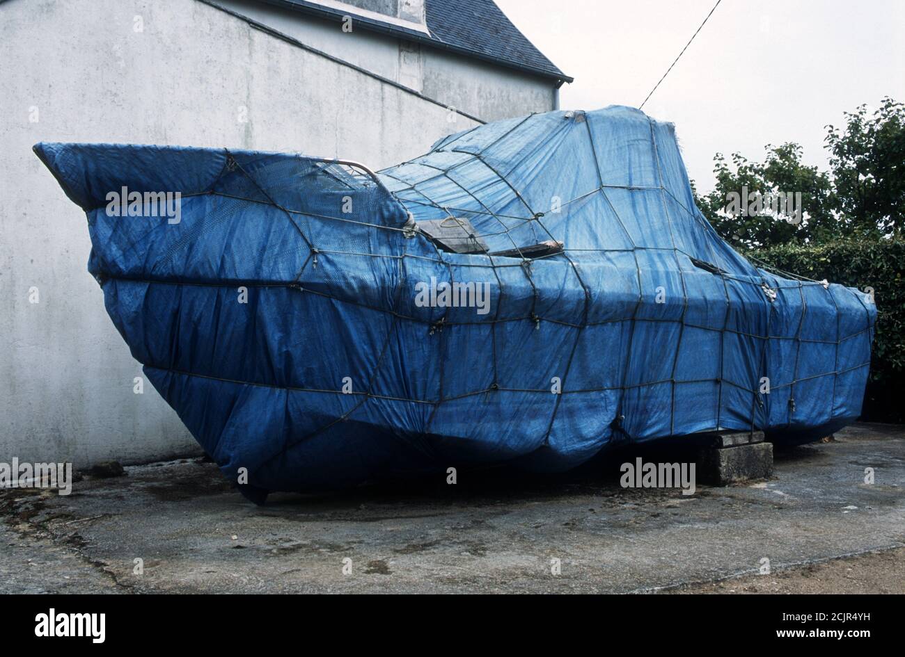 Motorboat wrapped up in blue plastic covering Stock Photo