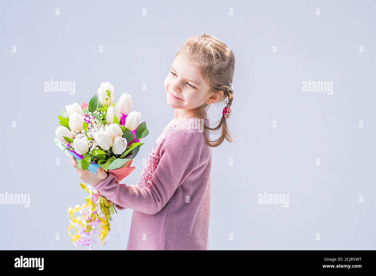 beautiful little girl with a bouquet of white tulips Stock Photo - Alamy