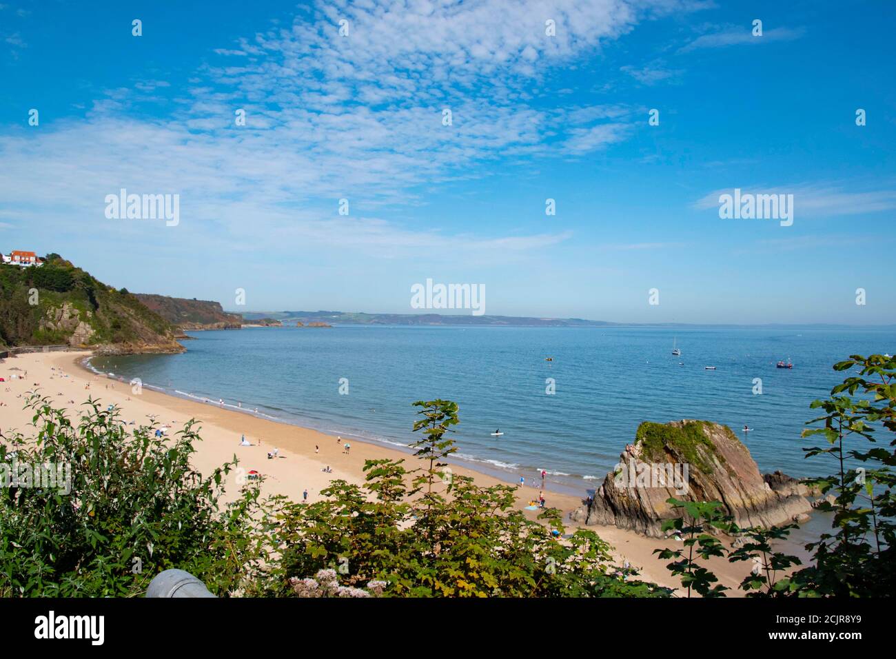 Tenby North beach sandy beach with the pinnacle of Goskar rock sticking out of the sand in the middle. Stock Photo