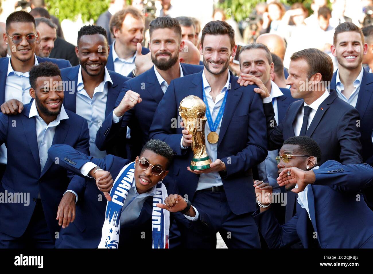 French President Emmanuel Macron reacts with France soccer team captain Hugo Lloris holding the