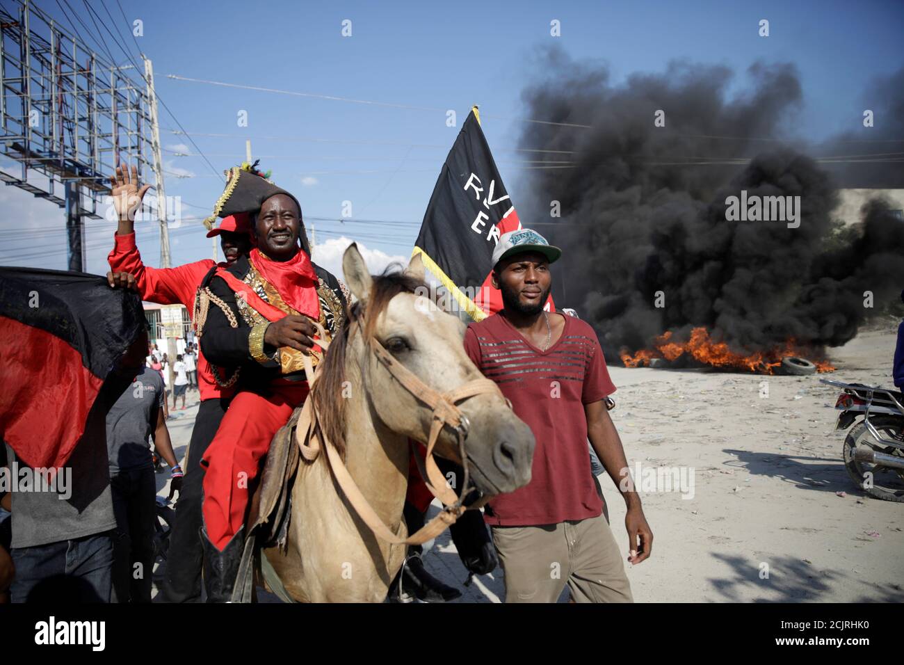 A man dressed as Haitian Revolution leader Jean-Jacques Dessalines rides a  horse together with Piti Desalin political party president, Moise Jean- Charles, during a march to demand the resignation of Haitian President  Jovenel