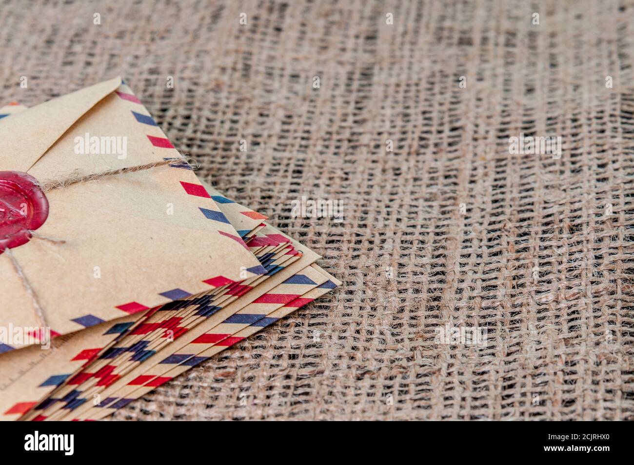 Old letters envelopes with a wax magic stamp triquetra on burlap Stock Photo