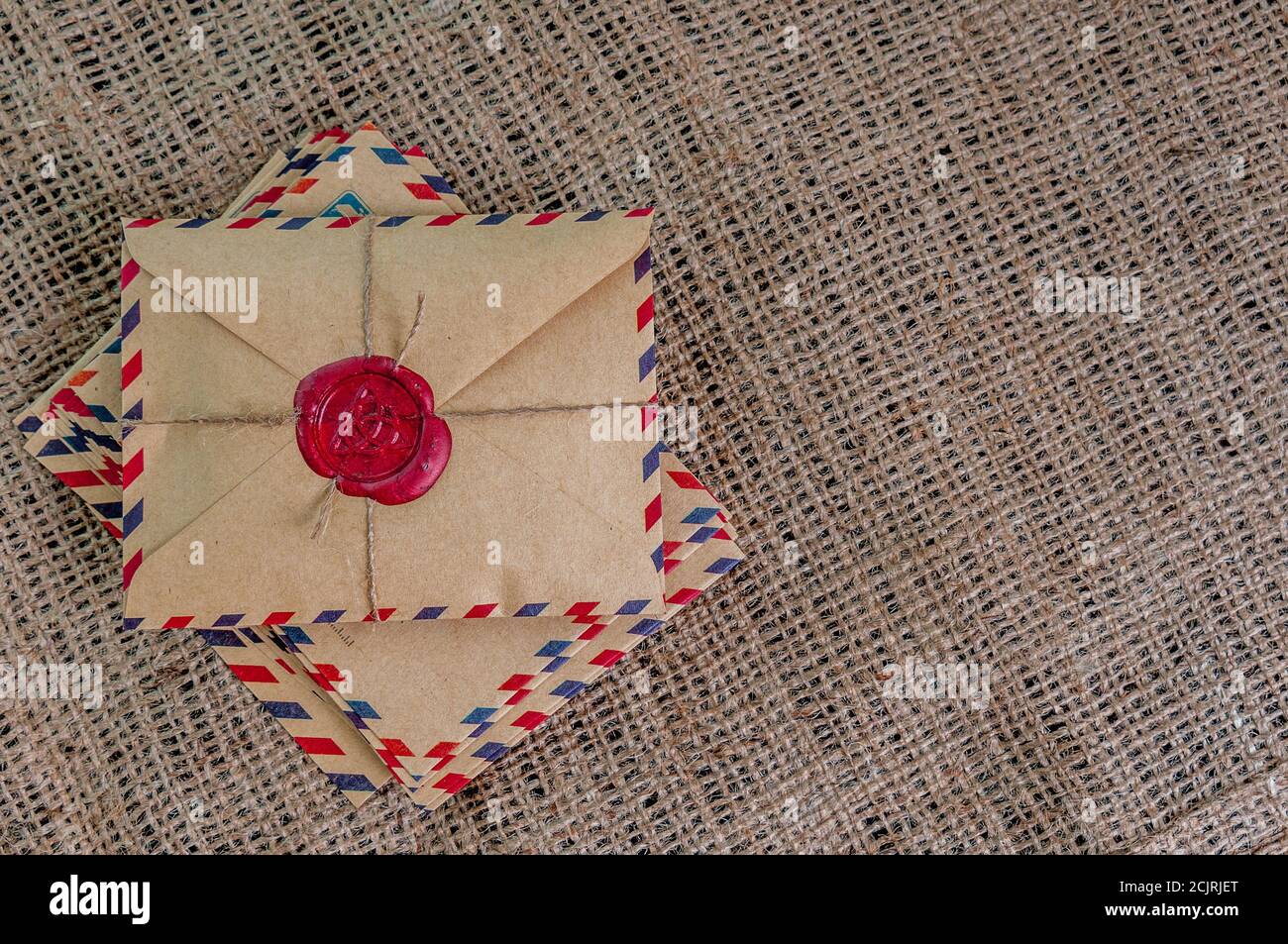 Old letters envelopes with a wax magic stamp triquetra on burlap Stock Photo
