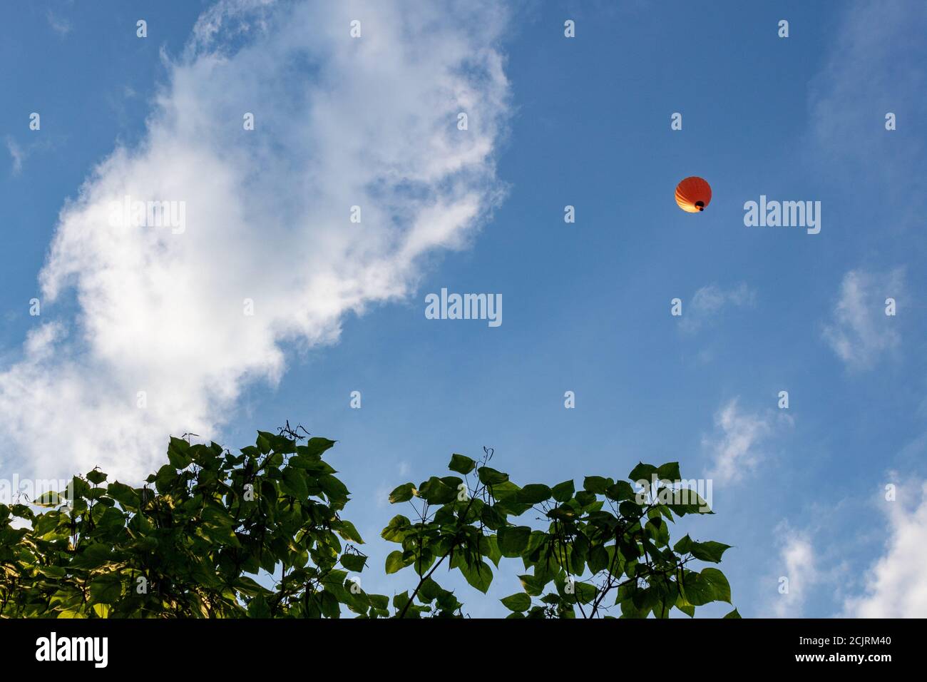 Low angle shot of a hot air balloon flying through the blue sky during ...