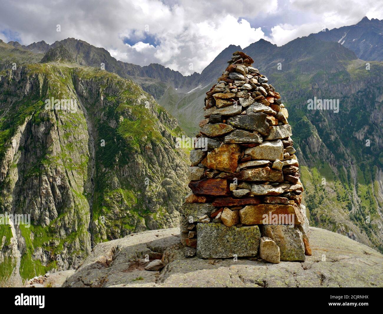 Ein Steinhaufen auf dem Berg, vor den wunderschönen Schweizer Alpen. Stock Photo