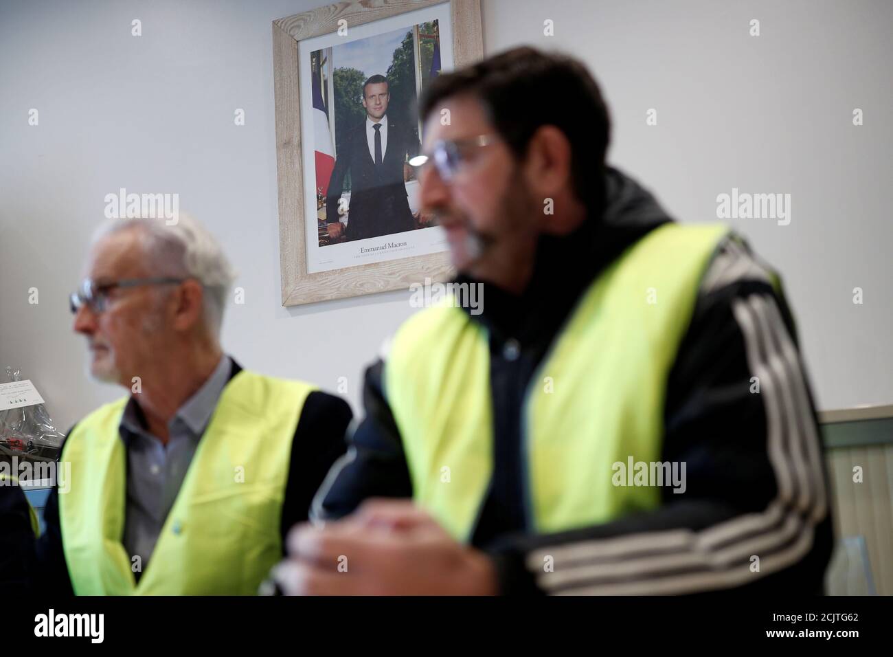 Yellow vests movement members Myrtil Devillers and Giles Piat attend a meeting at the city hall in Flagy, France, January 9, 2019. On the wall, the official portrait of French President Emmanuel Macron. Picture taken January 9, 2019.  REUTERS/Benoit Tessier Stock Photo
