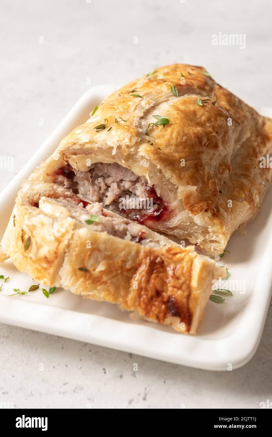 Baked pork turkey sausage rolls with brie cheese and cranberry sauce in