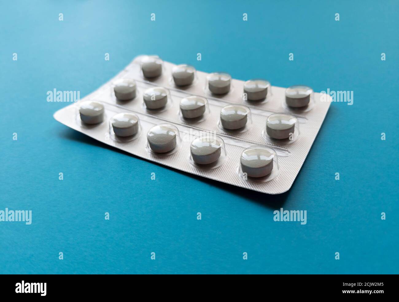 A blister of tablets on blue background. Medical concept. Stock photo. Stock Photo